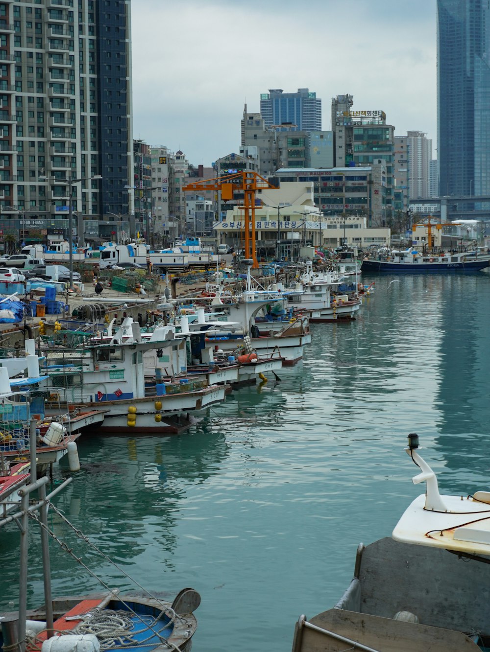 a harbor filled with lots of boats next to tall buildings