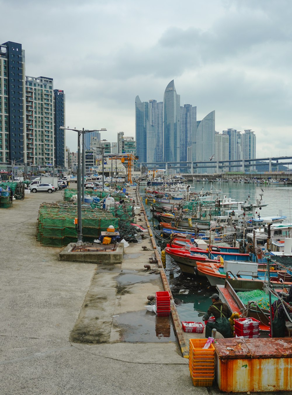 a harbor filled with lots of boats next to tall buildings