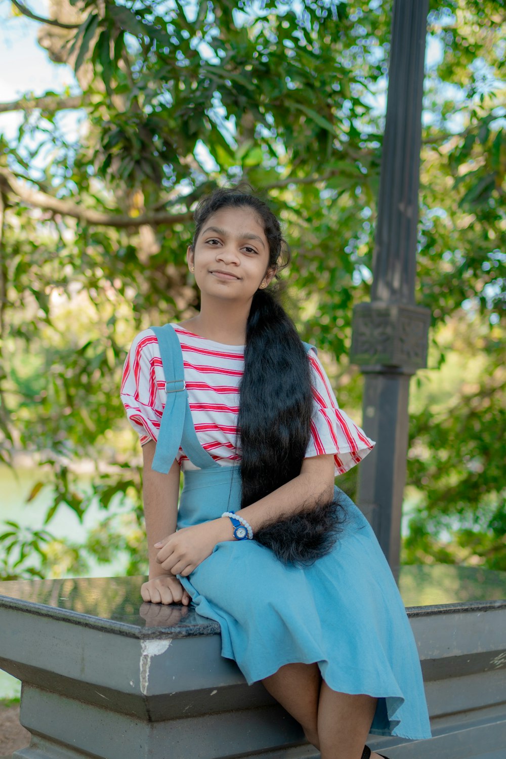 a girl with long hair sitting on a bench