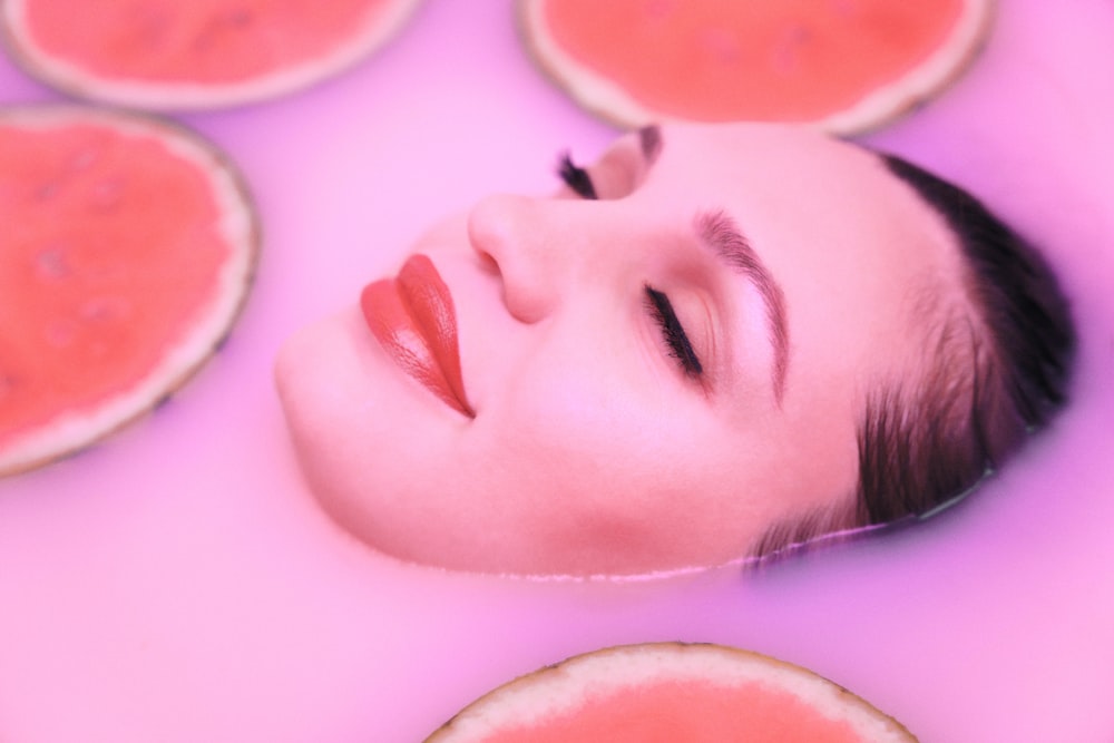 a woman laying in a bath of watermelon slices
