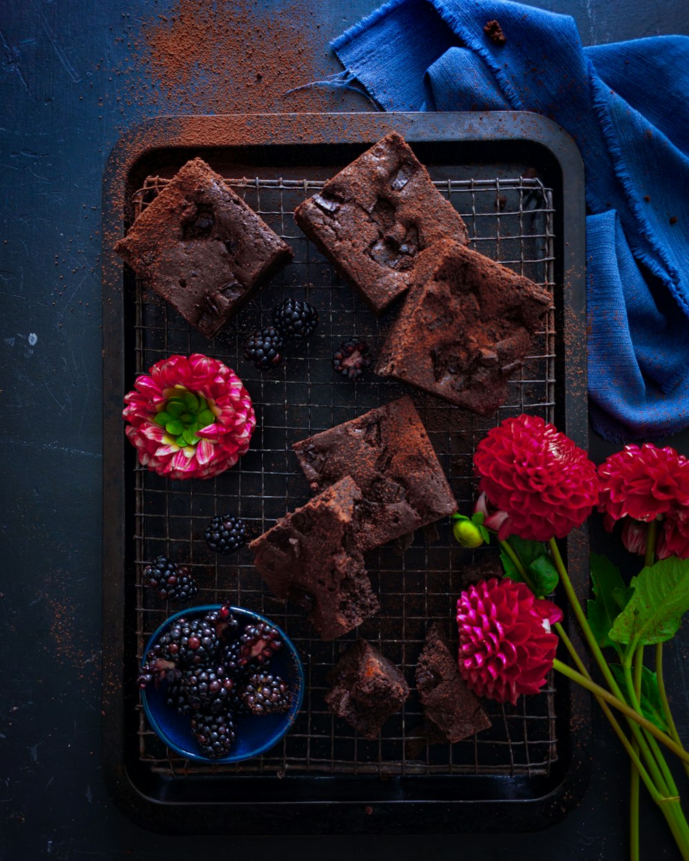 a tray of brownies and flowers on a table