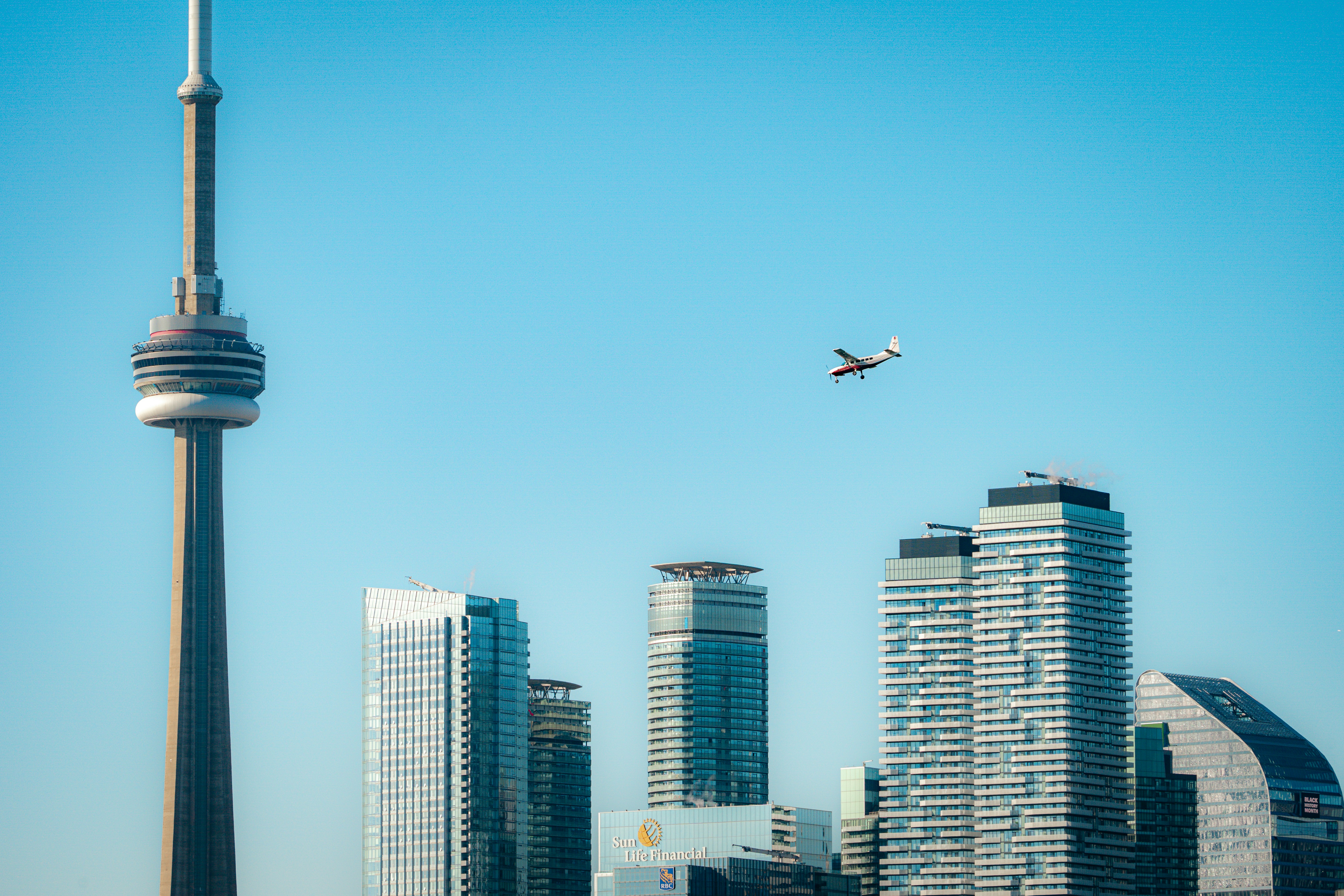 un avion survolant une ville avec de grands immeubles