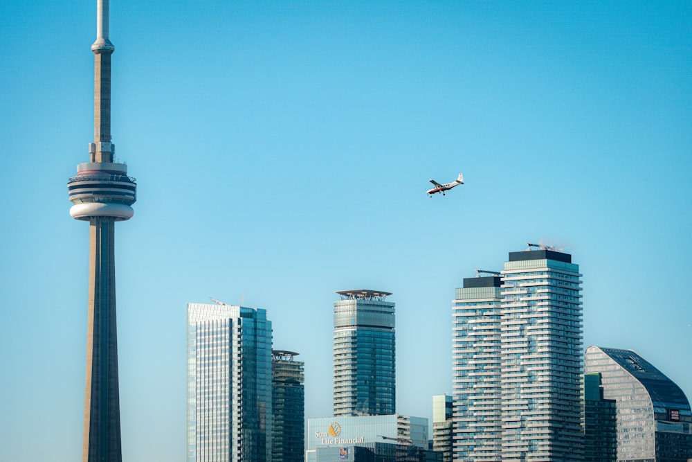 an airplane flying over a city with tall buildings