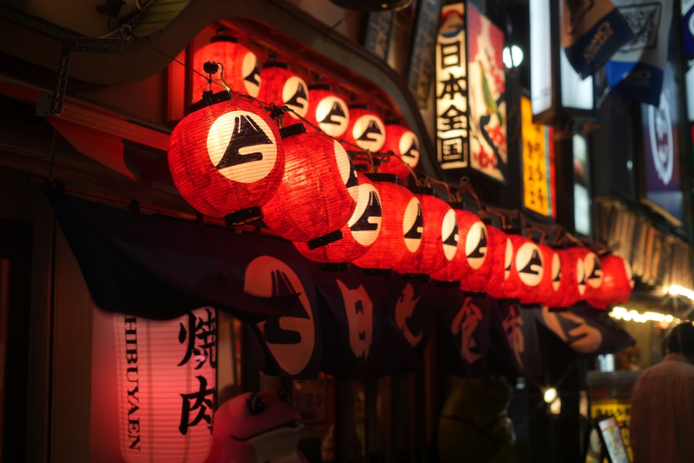 a row of red lanterns hanging from the side of a building