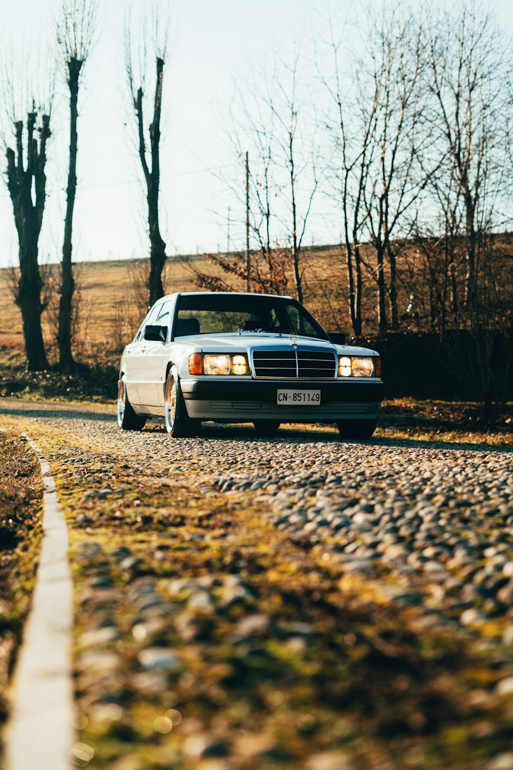 a car is parked on a gravel road