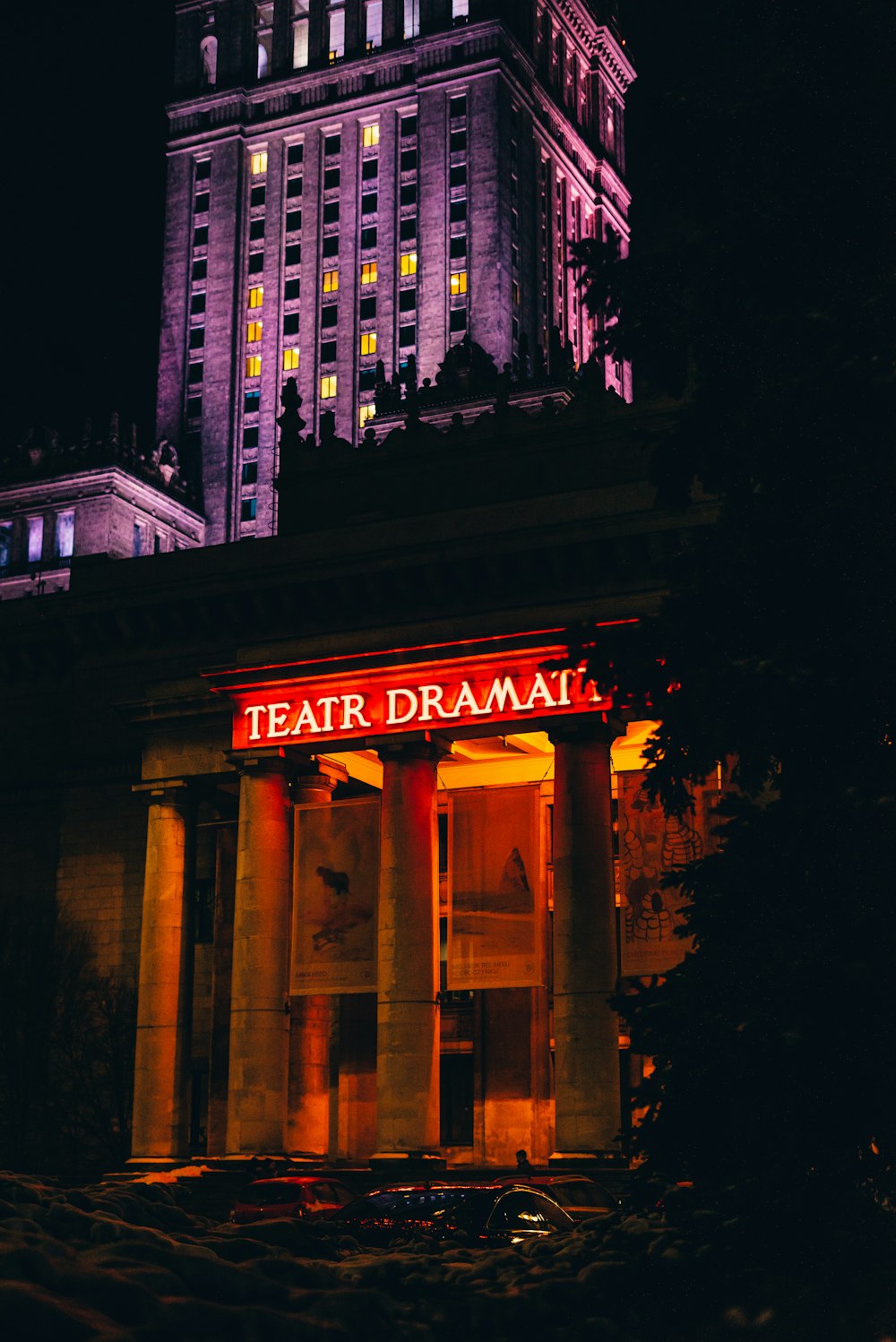 a tall building with a lit up sign in front of it