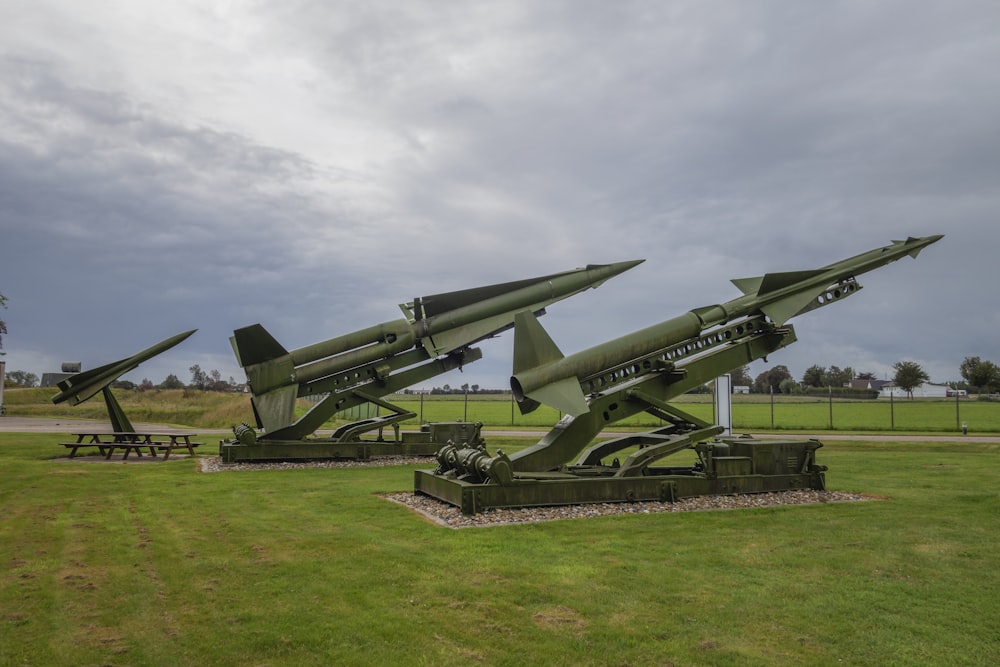 a group of military missiles sitting on top of a field