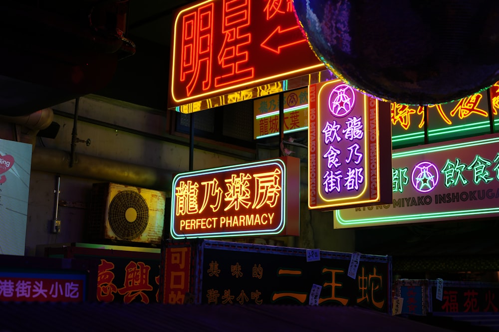 a bunch of signs that are lit up in the dark
