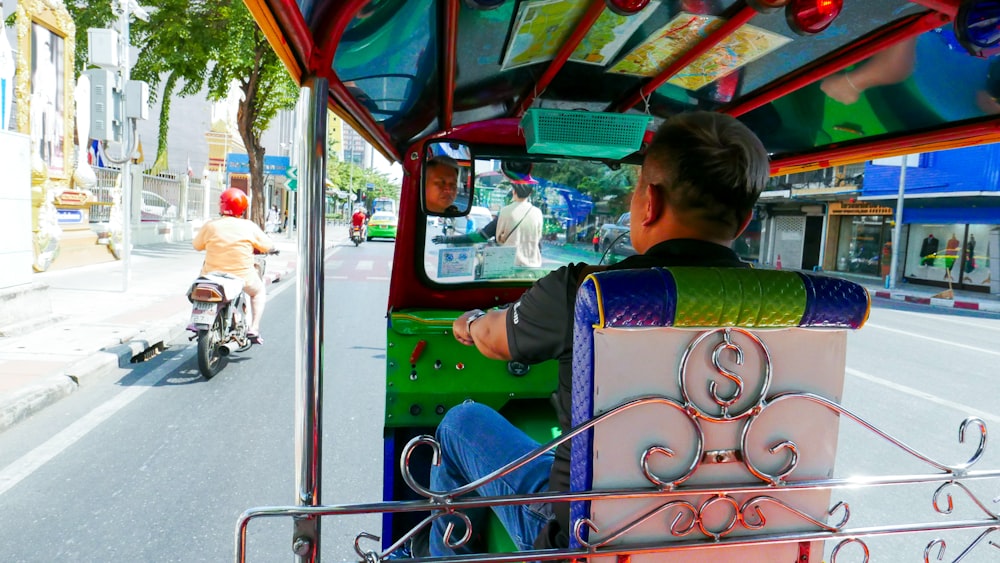 a man driving a colorful bus down a street