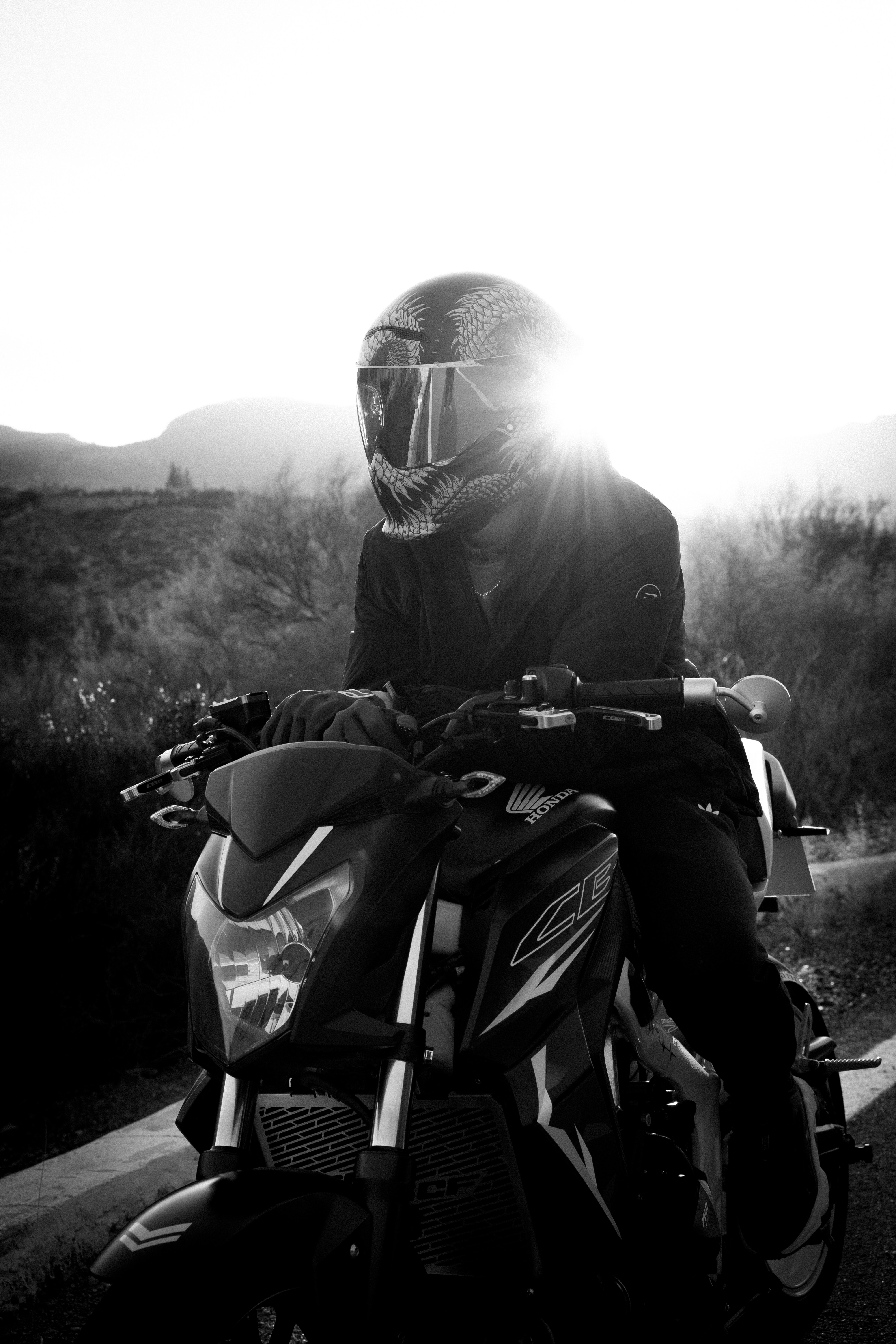a person sitting on a motorcycle on a road