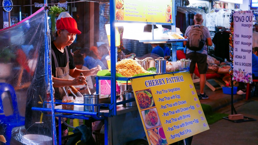 a man standing in front of a food stand