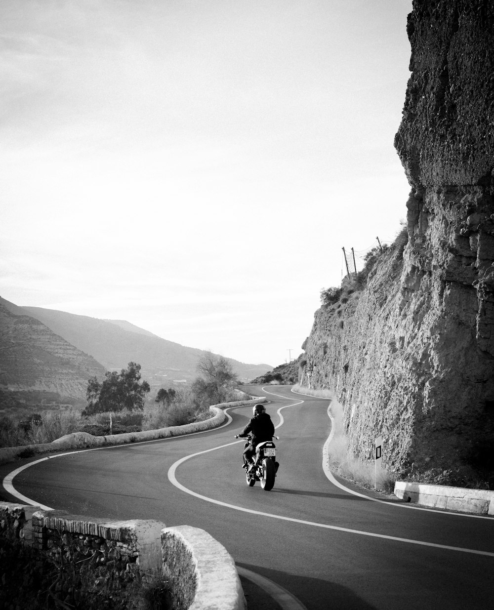 a man riding a motorcycle down a curvy road