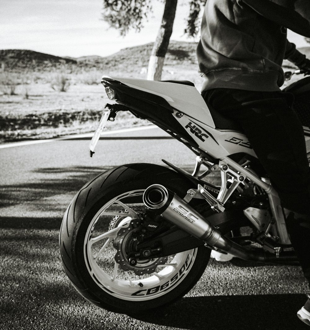 a black and white photo of a person riding a motorcycle