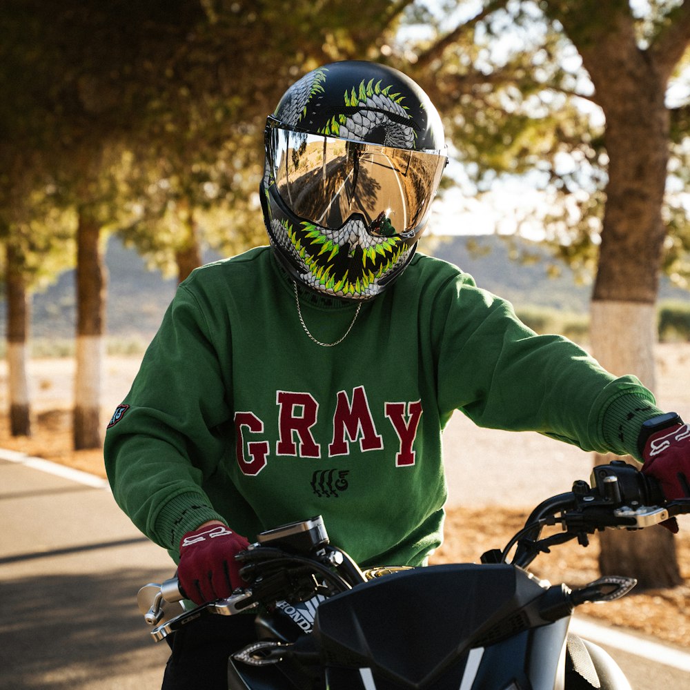 a man in a green shirt is riding a motorcycle