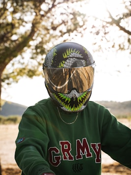 a person wearing a green shirt and a motorcycle helmet