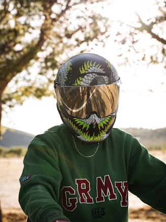 a person wearing a green shirt and a motorcycle helmet