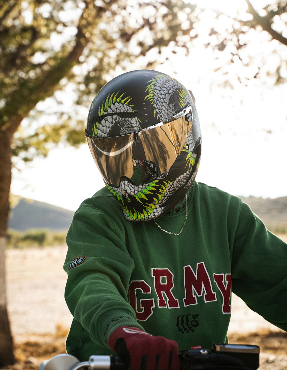 a person in a green shirt wearing a motorcycle helmet
