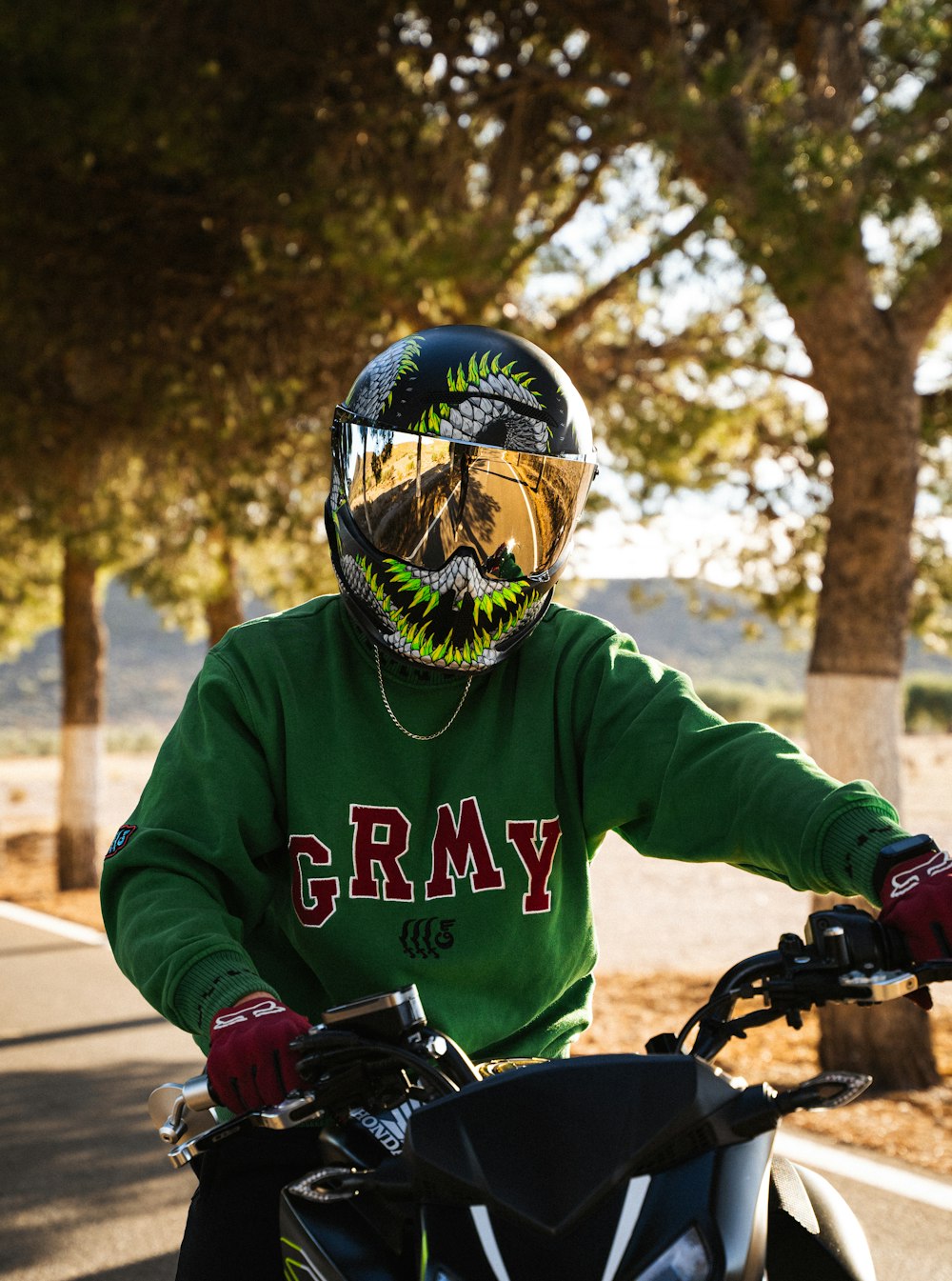 a man in a green shirt is riding a motorcycle
