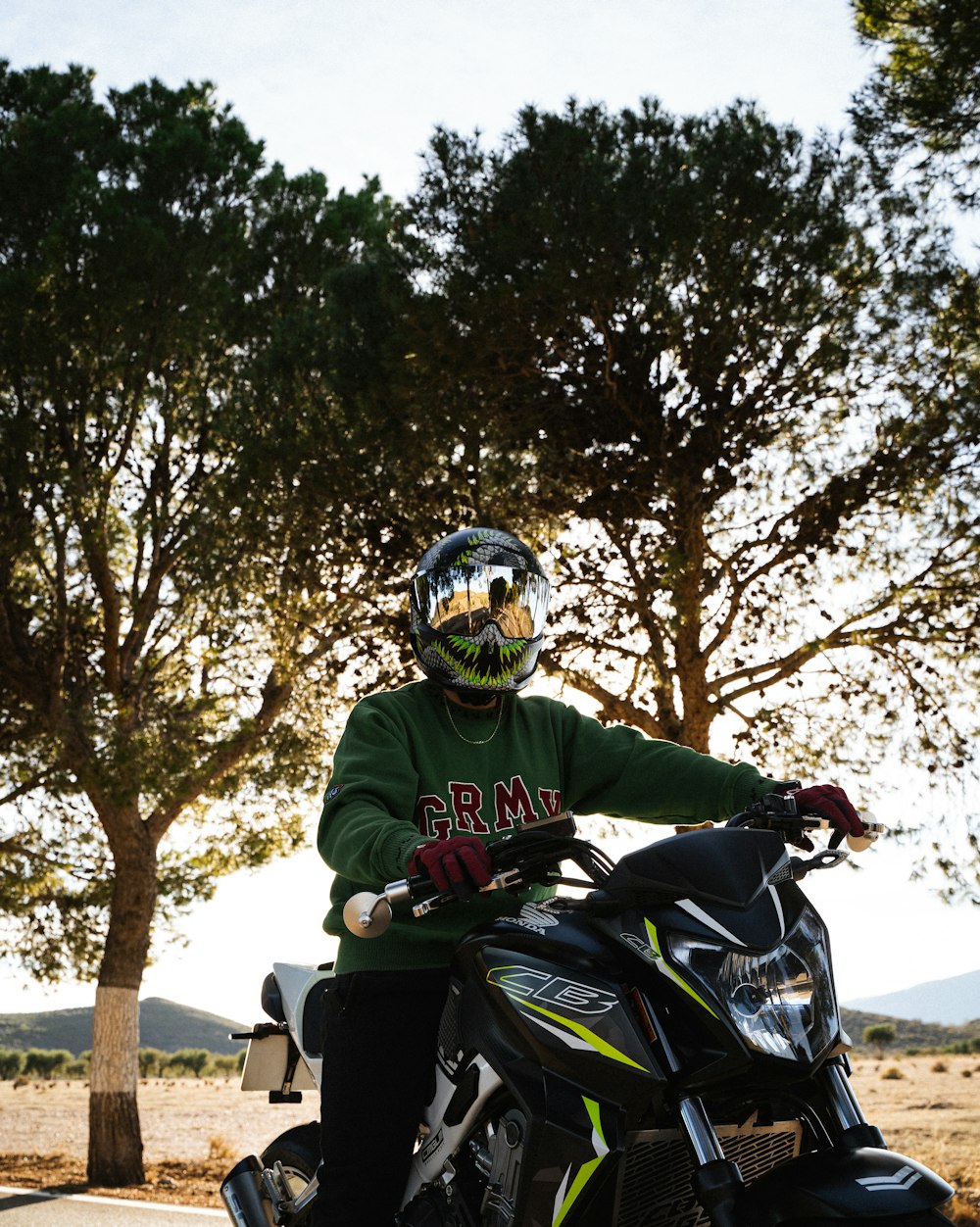 a person on a motorcycle with trees in the background