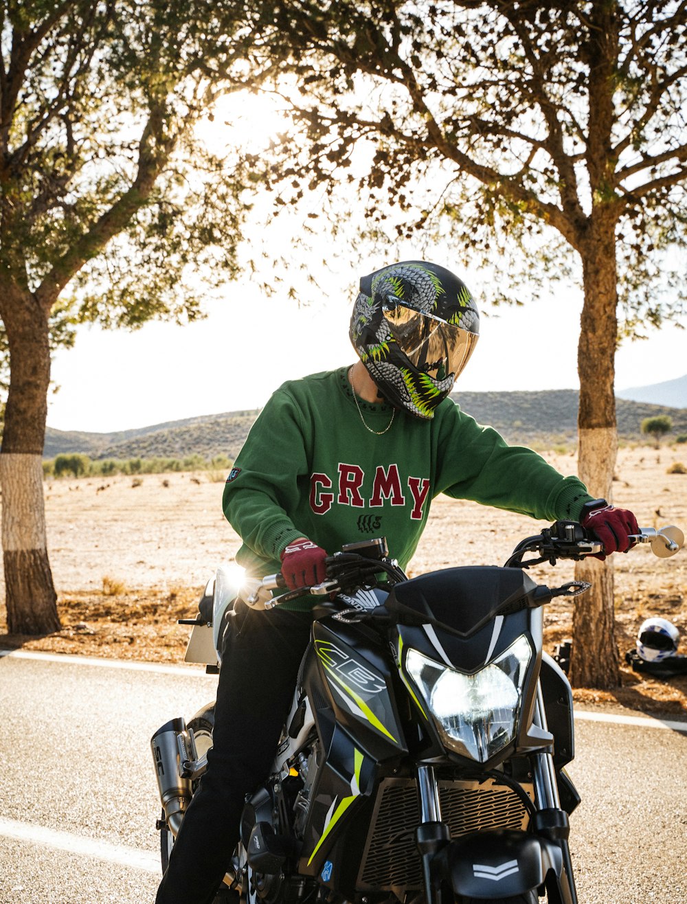 a man in a green shirt is riding a motorcycle
