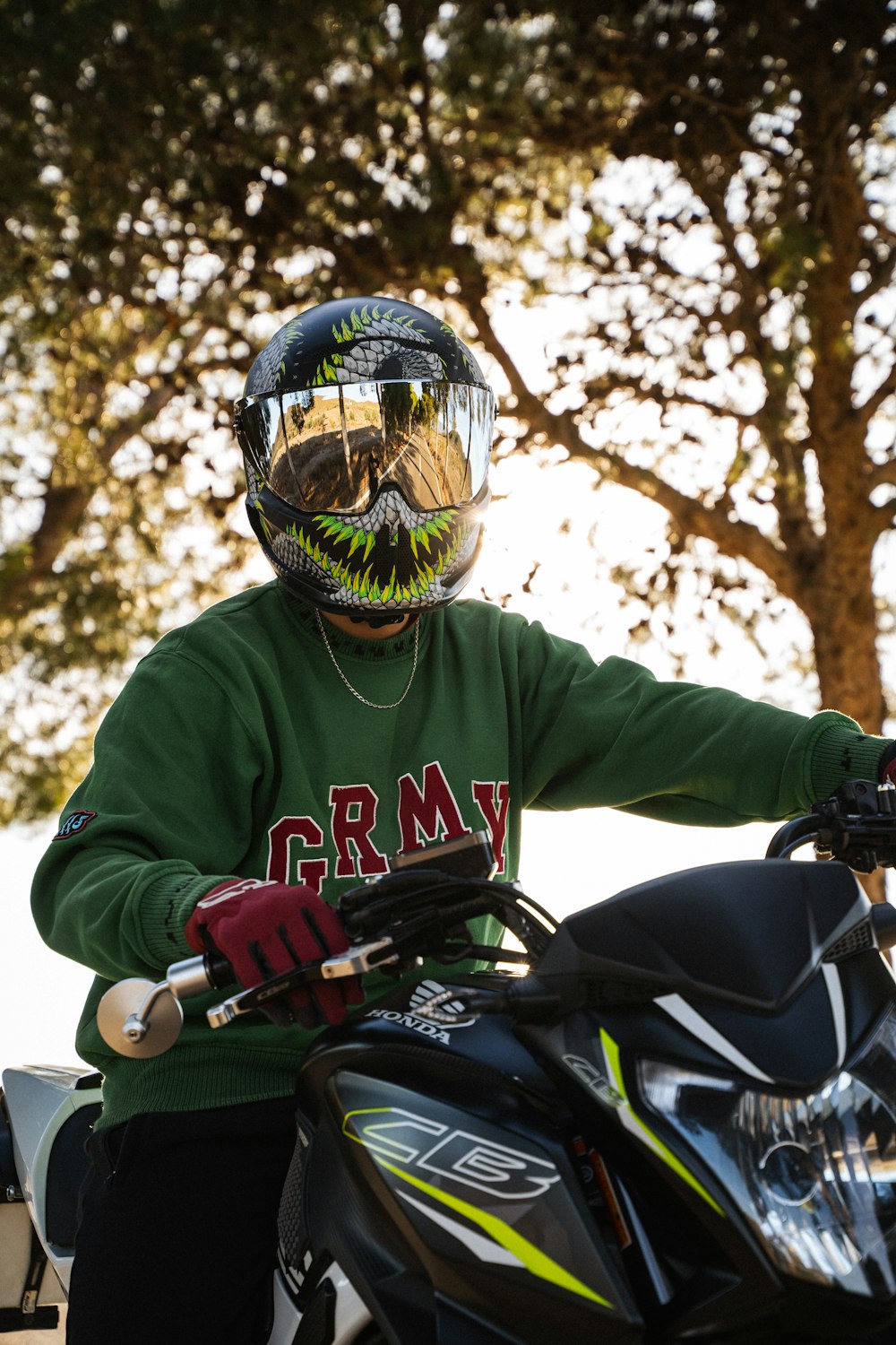 a person wearing a helmet and sitting on a motorcycle