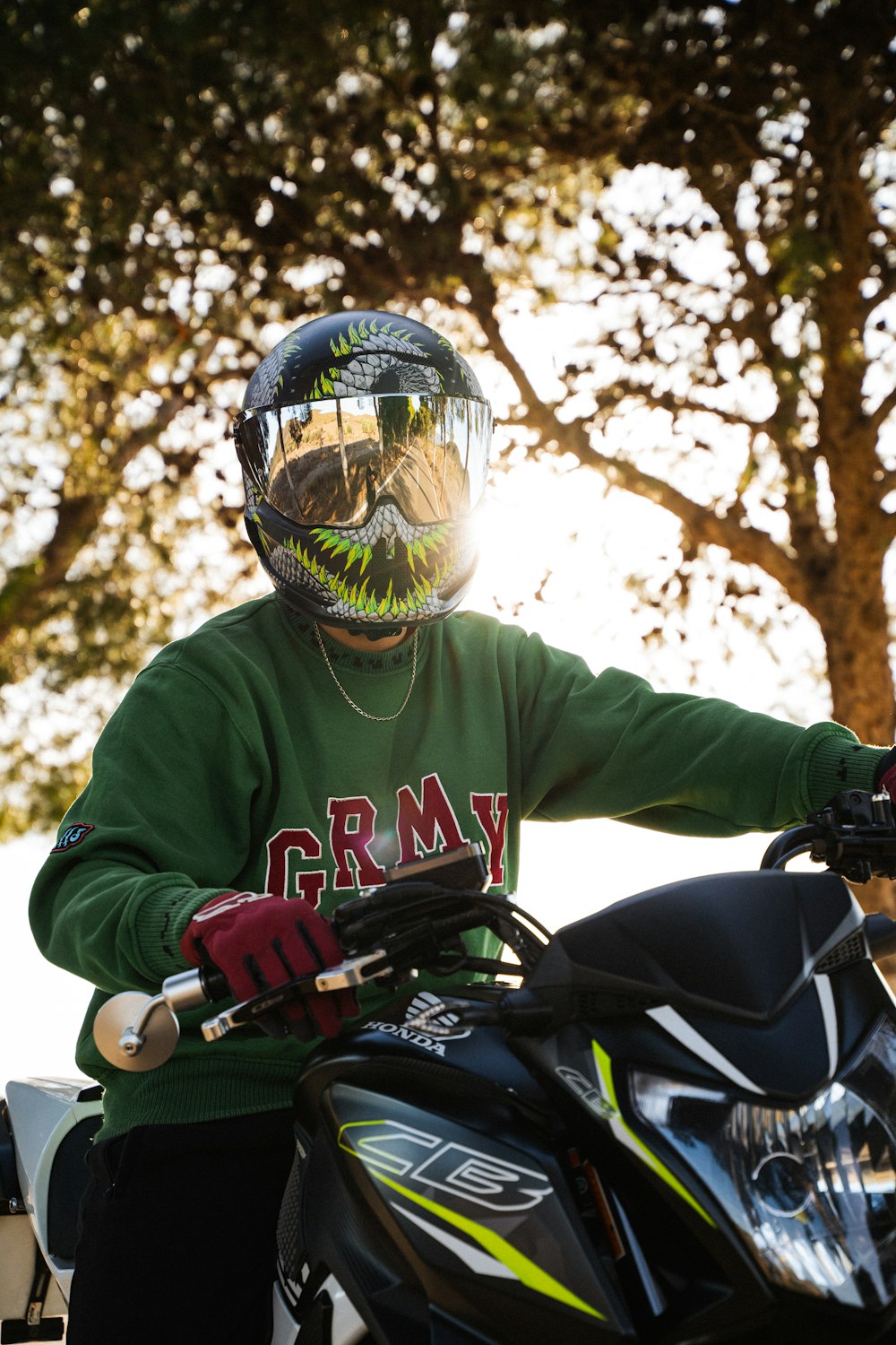 a man in a green shirt is sitting on a motorcycle