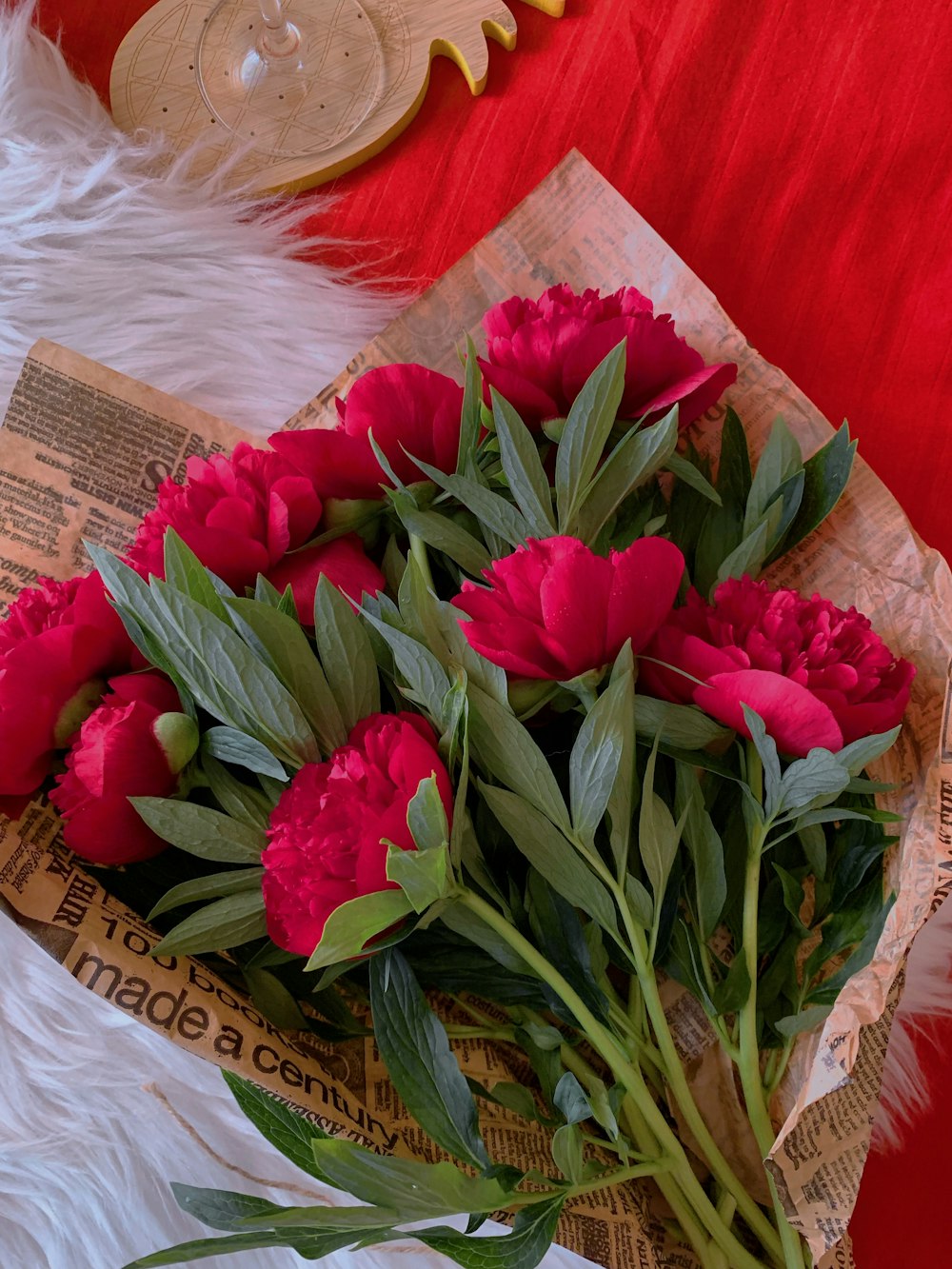 un mazzo di fiori rossi seduto sopra un tavolo