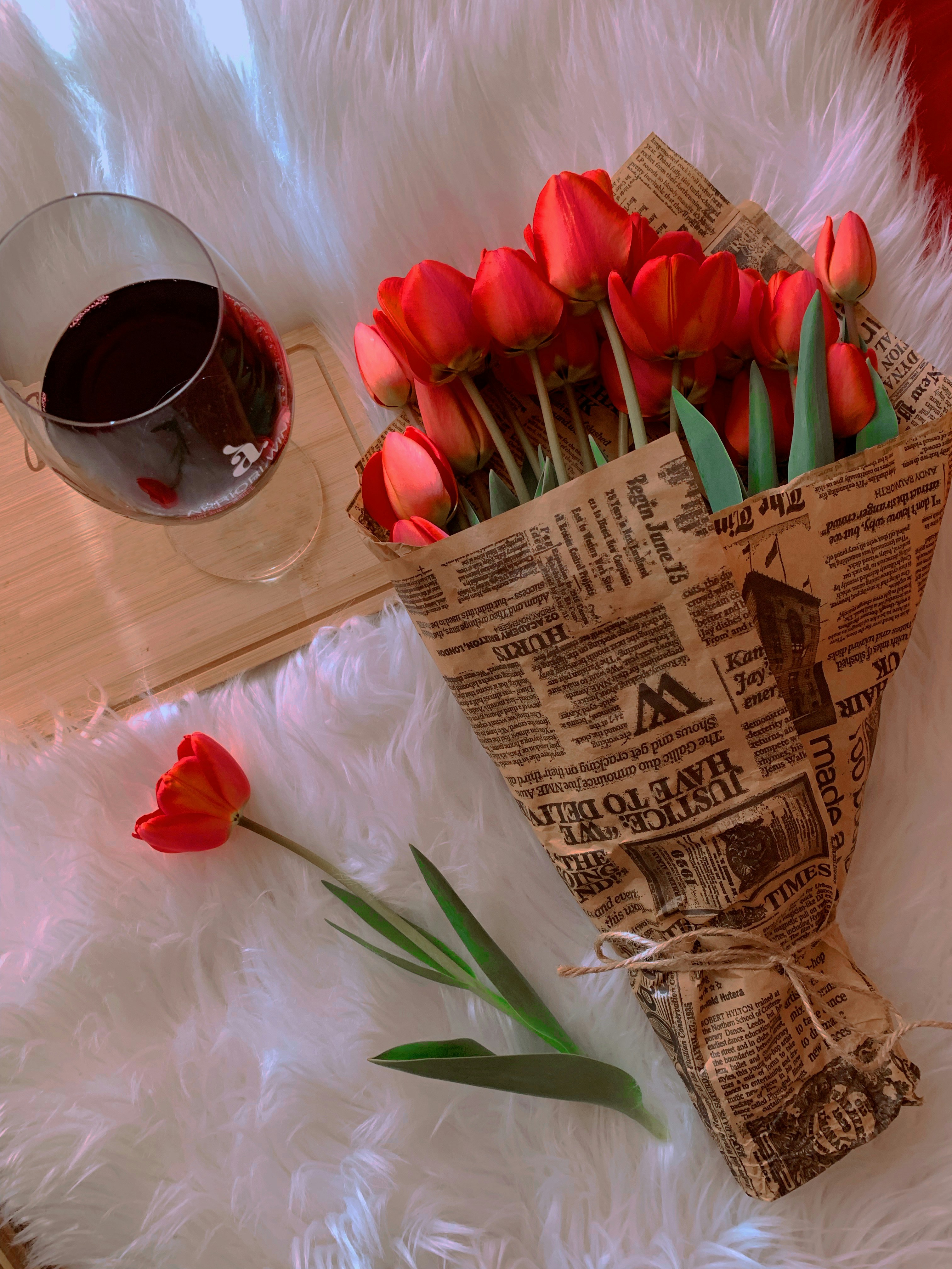 a bouquet of red tulips in a paper bag