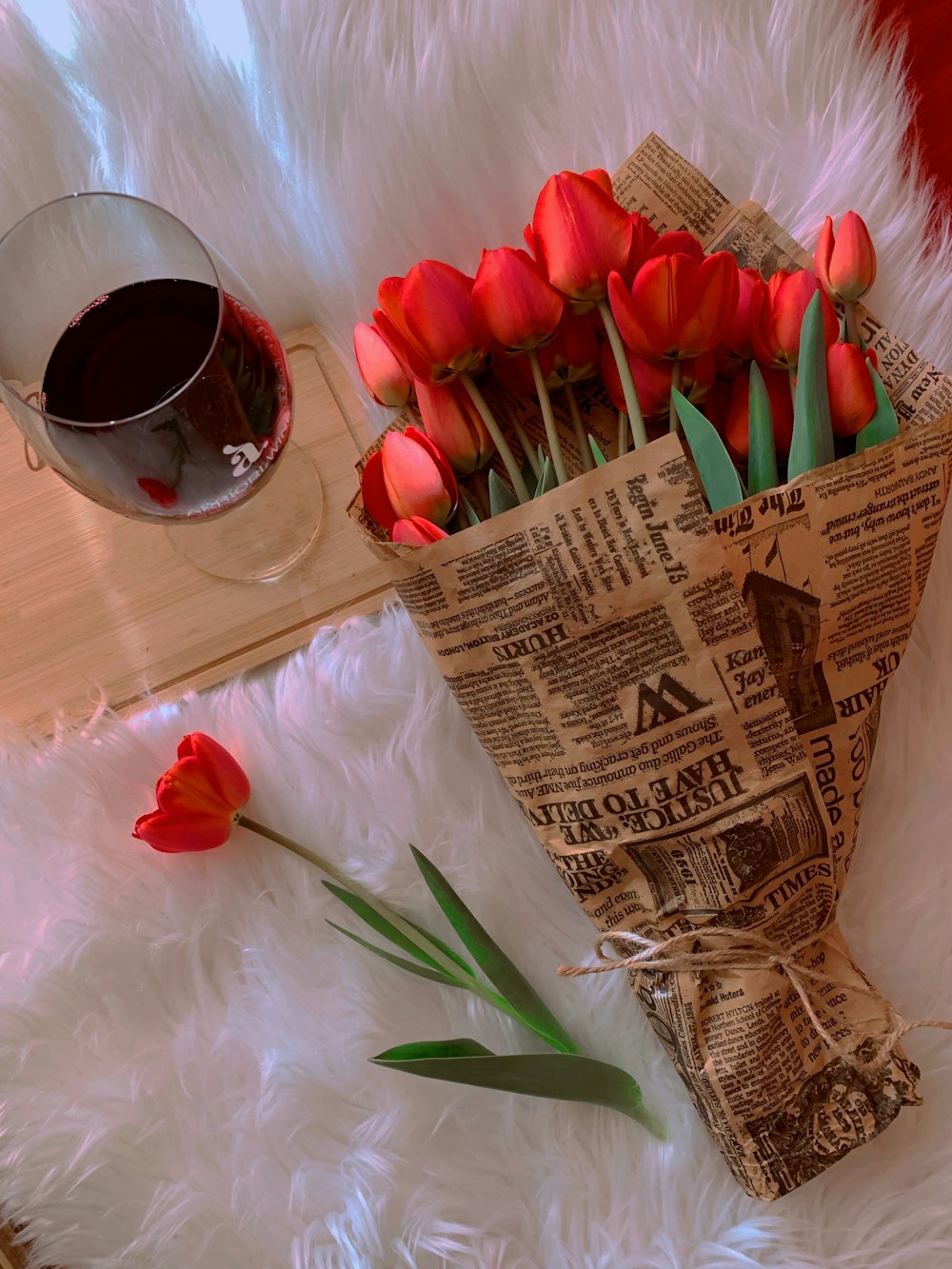 a bouquet of red tulips in a paper bag