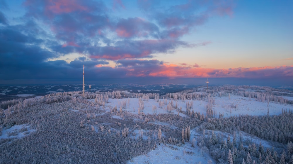 a beautiful sunset over a snowy landscape with trees