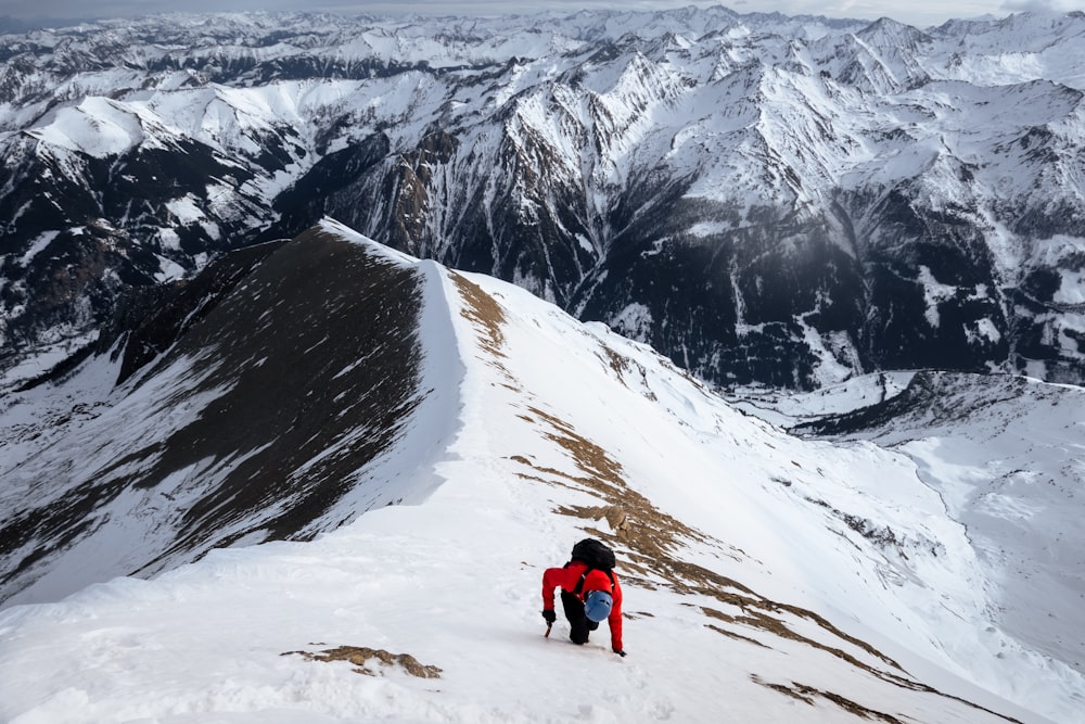 a man climbing up a snow covered mountain