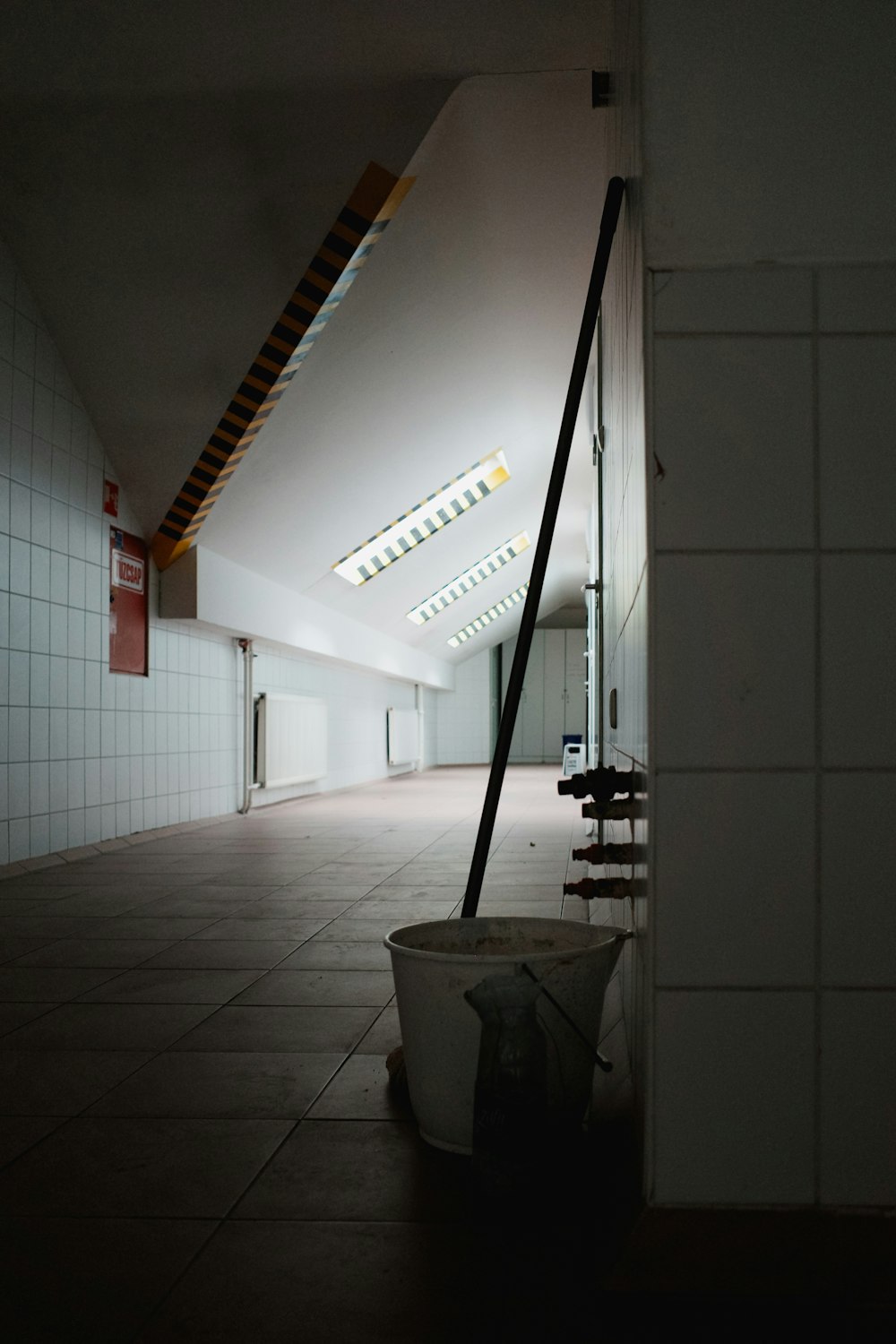 a long hallway with a bucket of trash on the floor