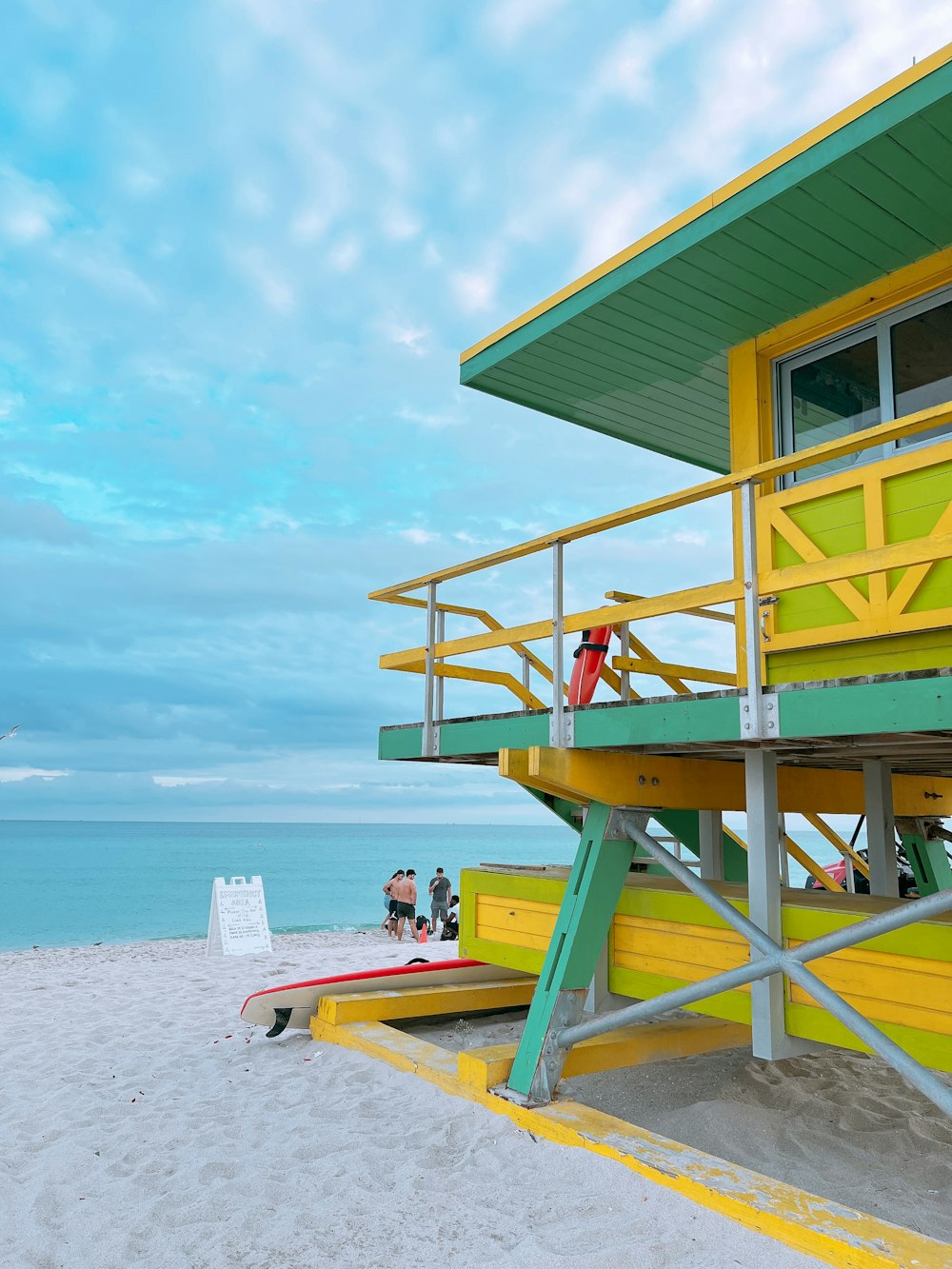 a lifeguard station on a beach with people standing on it