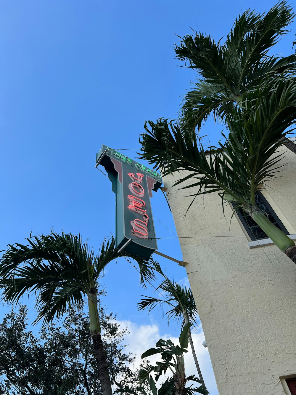 a neon sign hanging from the side of a building