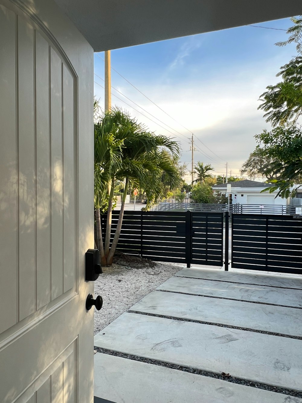 a white door with a black fence in the background