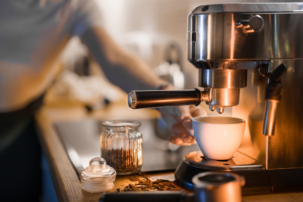 Una cafetera está preparando una taza de café