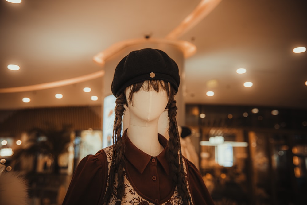 a mannequin with long braids wearing a hat