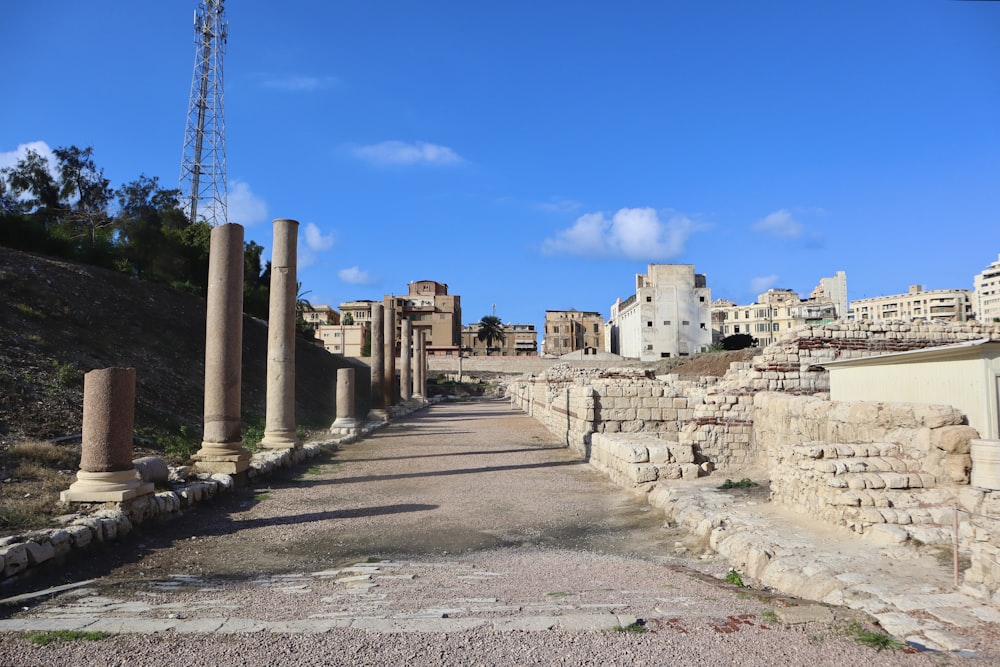 una strada fiancheggiata da pilastri ed edifici in pietra