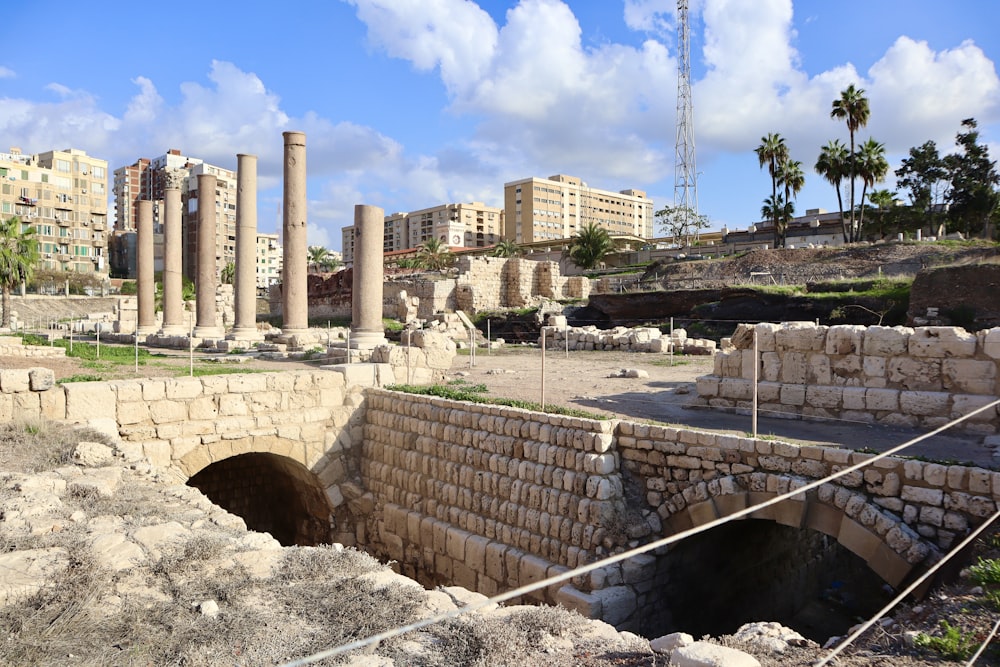 the ruins of a roman city with palm trees in the background