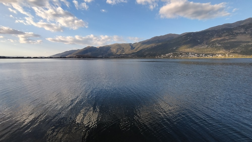 a body of water with mountains in the background