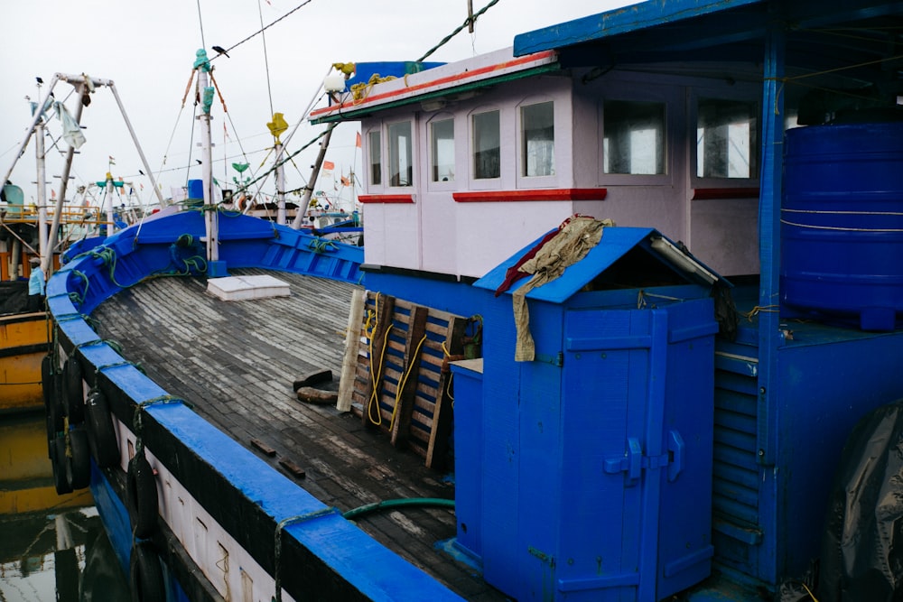 a blue and white boat docked at a pier