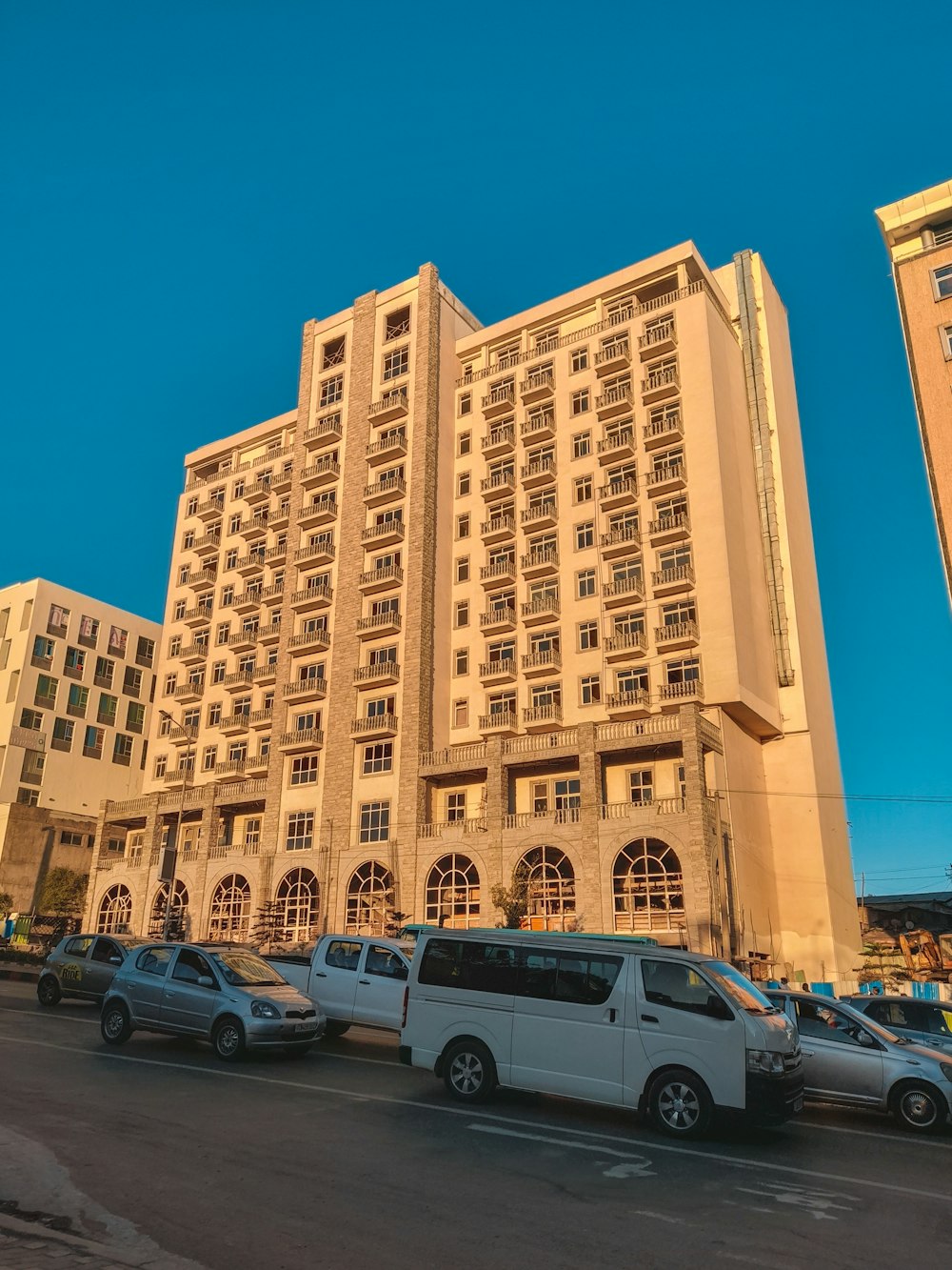 a very tall building with a bunch of cars parked in front of it