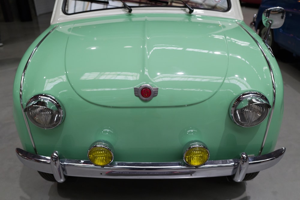 an old green car is parked in a garage