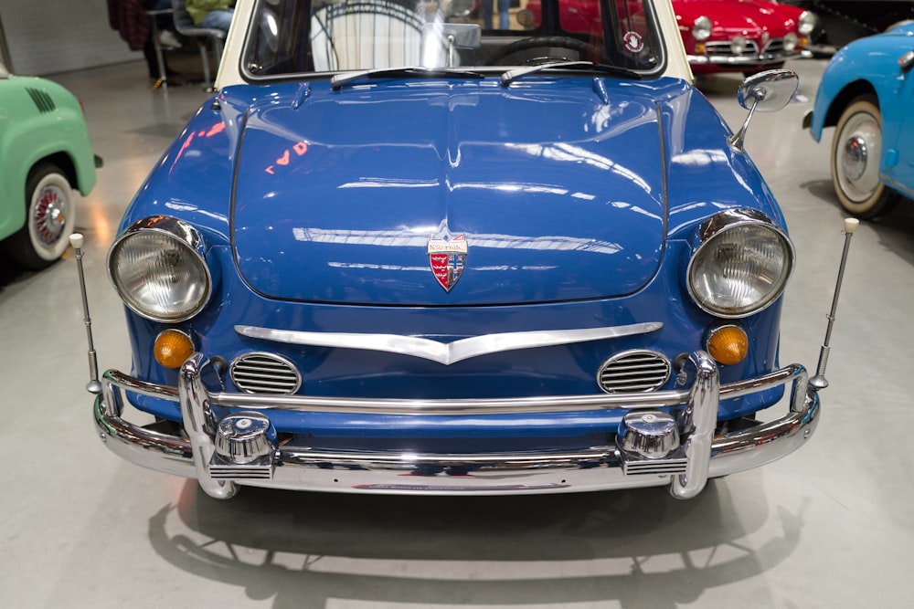 a blue car parked in a garage next to other cars