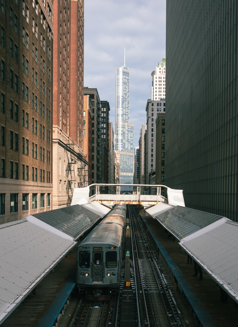 a train traveling through a city next to tall buildings