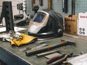 a welding helmet sitting on top of a workbench