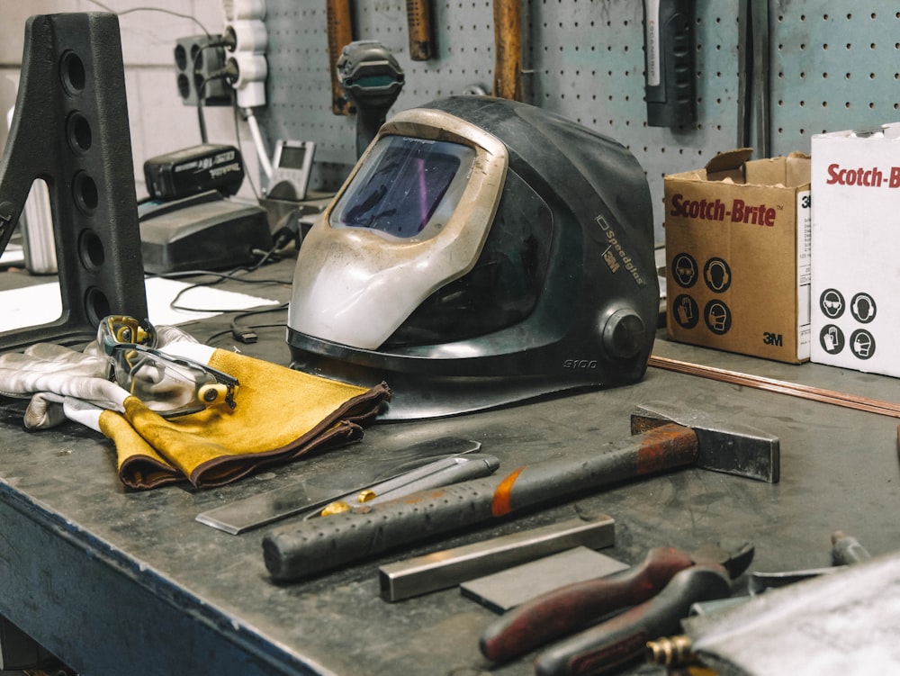 a welding helmet sitting on top of a workbench