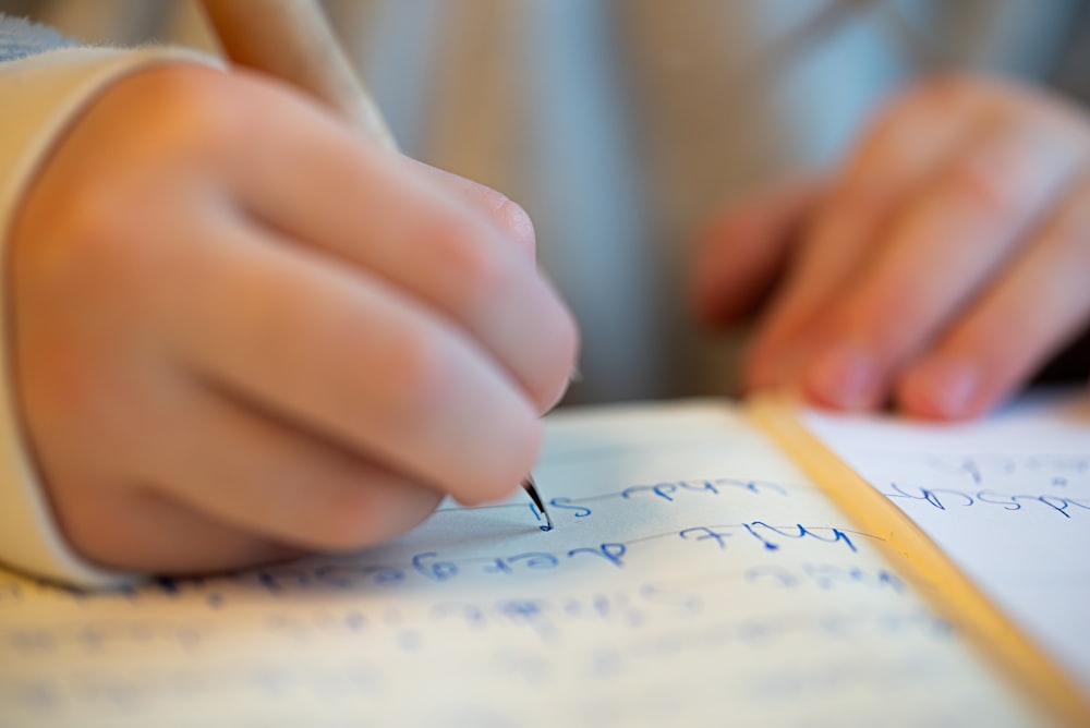 a person writing on a piece of paper