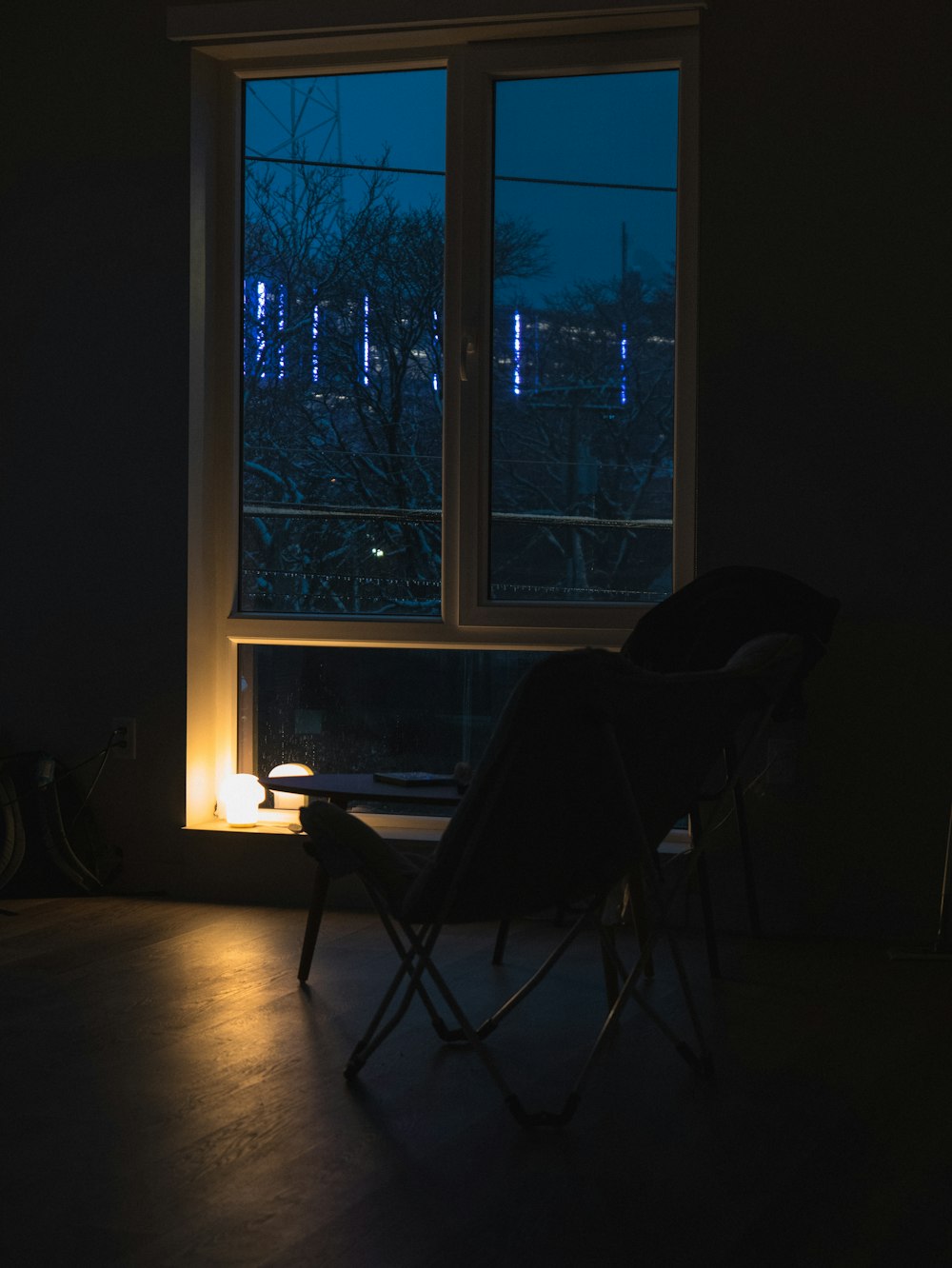 a chair sitting in front of a window in a dark room