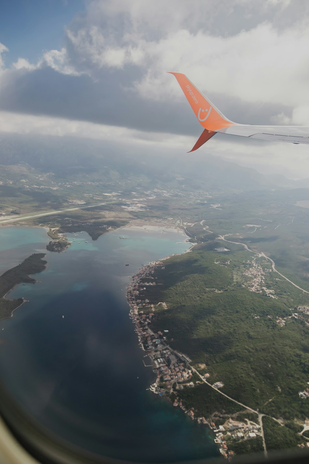 an airplane wing flying over a large body of water